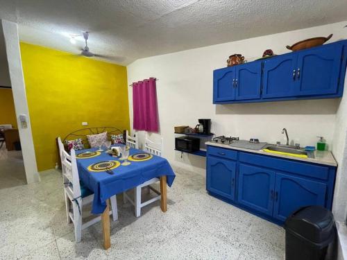 a kitchen with blue cabinets and a table with a blue table cloth at Casa Alebrijes in La Paz