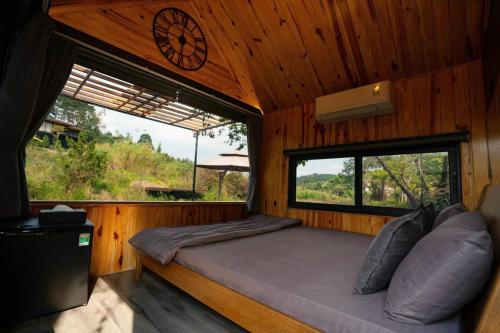 Postel nebo postele na pokoji v ubytování Khu Nghỉ Dưỡng Ngôi Làng Trong Tranh, Bảo Lộc