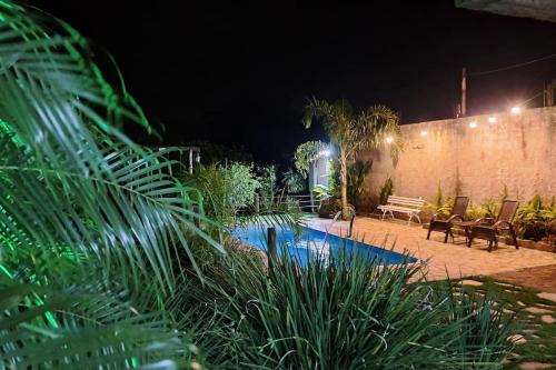 a garden at night with a swimming pool at Casa de campo (chácara) em Louveira in Louveira
