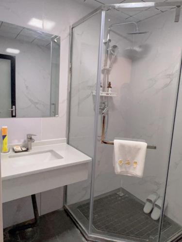 a bathroom with a shower and a sink at 三亚观海楼酒店（三亚湾椰梦长廊店） in Sanya