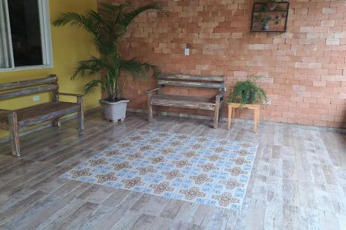 a room with benches and a rug and a brick wall at Casa de campo (chácara) em Louveira in Louveira