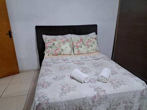 a bed with two towels and two pillows on it at Casa de campo (chácara) em Louveira in Louveira