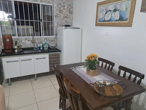 a kitchen with a table with chairs and a refrigerator at Casa de campo (chácara) em Louveira in Louveira