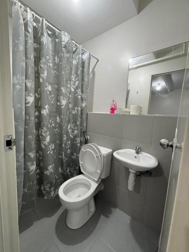 a bathroom with a toilet and a sink at Casa Moanna 2BR Condo with Dining, kitchen, Living Area and Netflix in Mandaue City