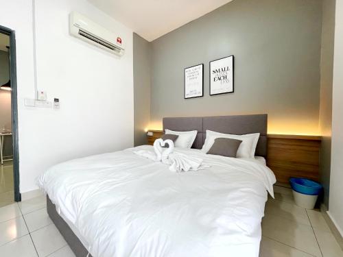 a large white bed with a white towel on it at MesaHill Homestay, Nilai by S&T Homez in Nilai