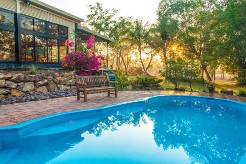 a swimming pool with a bench next to a house at Breeze Holiday Parks - Mary River in Marrakai