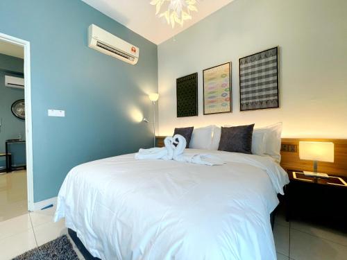 a bedroom with a white bed with a towel on it at MesaHill Homestay, Nilai by S&T Homez in Nilai