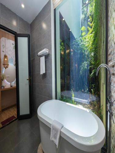 a bathroom with a bath tub and an aquarium at Villa 3 phòng ngủ thiên nhiên - bể bơi - đầy đủ tiện nghi in Phúc Yên