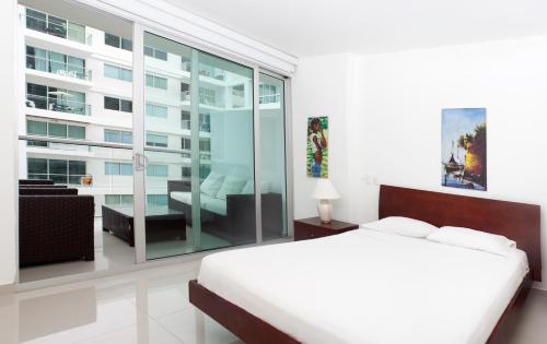 Dormitorio blanco con cama y ventana grande en Apartamento Morros Ultra 511, en Cartagena de Indias