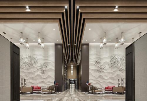 a lobby with tables and chairs in a building at Mandarin Oriental, Shenzhen in Shenzhen