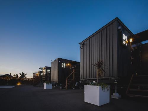 a couple of black shipping containers in a parking lot at Seage Torami Coastside in Ichinomiya