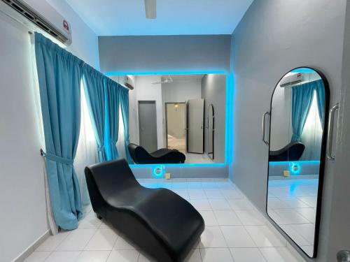 a bathroom with a black chair in front of a mirror at MesaHill Homestay, Nilai by S&T Homez in Nilai