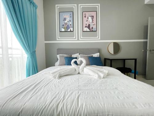 two swans towels on top of a white bed at MesaHill Homestay, Nilai by S&T Homez in Nilai
