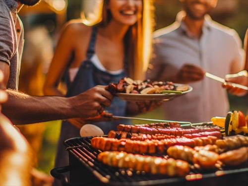 a group of people standing around a barbecue grill at Seage Torami Coastside in Ichinomiya