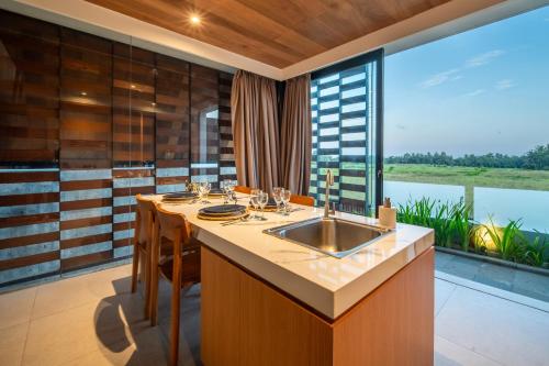 a kitchen with a sink and a large window at Oasis Loft - Ricefield Luxe View Ubud in Ubud