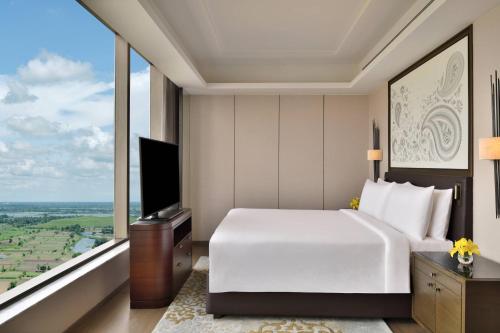 a bedroom with a large white bed and a large window at JW Marriott Hotel Kolkata in Kolkata