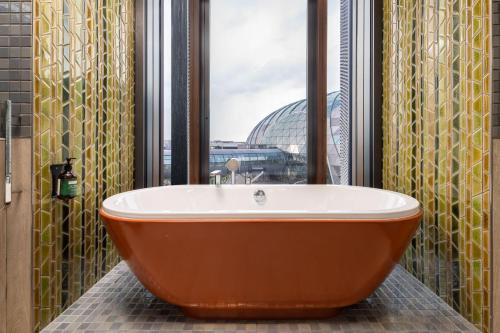 a bath tub in a bathroom with a large window at Crowne Plaza Changi Airport by IHG in Singapore