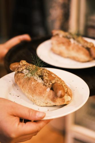 a person holding a plate with a hot dog on it at 紅花舎 koukasha in Yamaguchi
