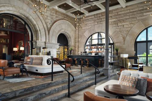 a lobby with a piano in a stone building at The Union Station Nashville Yards, Autograph Collection in Nashville