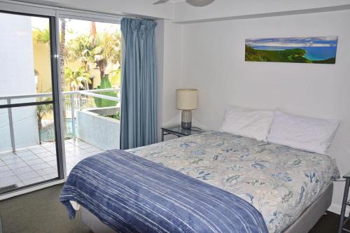 Un dormitorio con una cama y un balcón con vistas. en Ocean Shores Apartment 14 - Bring your own linen., en South West Rocks