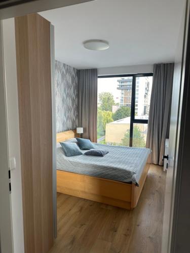 a bedroom with a bed and a large window at Olivia Baltic in Gdańsk