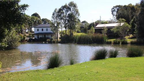 a house next to a pond in front of a house at Dusty Hill Vineyard - Moffatdale in Moffatdale