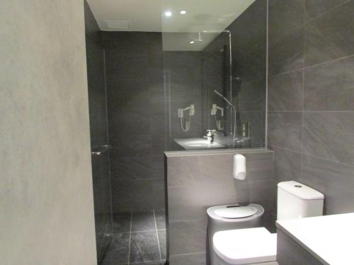 a bathroom with a toilet and a glass shower at Aerotel Singapore - Transit Hotel in Terminal 1 in Singapore