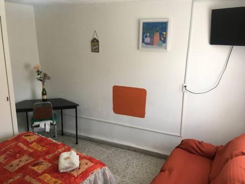 a room with a couch and a table and a tv at 3 Air Conditioned brs with Office Area, Gated Parking and Free Mini Pool Table in León