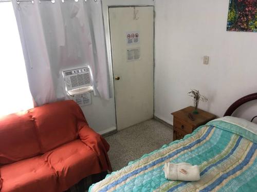 a bedroom with a bed and a door with a fan at 3 Air Conditioned brs with Office Area, Gated Parking and Free Mini Pool Table in León