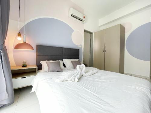 a bedroom with a white bed with a towel on it at MesaHill Homestay, Nilai by S&T Homez in Nilai