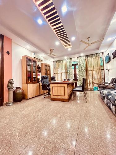 a living room with a desk and chairs in it at Hotel Satwah Home Stay Just 10 Minute Away From Nizamuddin Railway Station in New Delhi