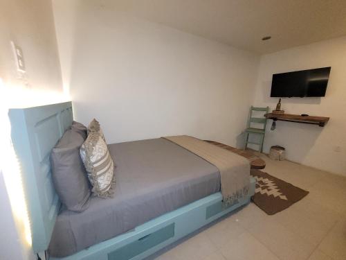 a bedroom with a bed and a flat screen tv at Hotel Casa Puerta de Mar in Campeche