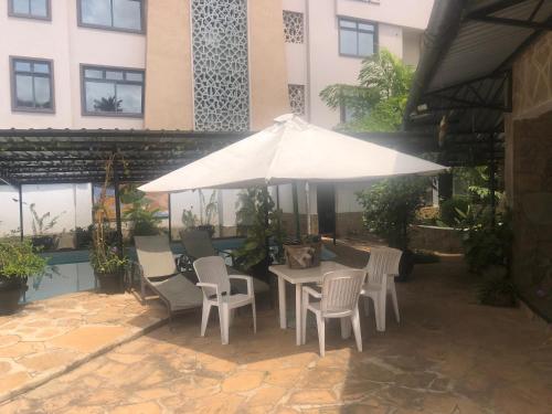 蒙巴萨Lusigi Luxe villas的带桌椅和遮阳伞的露台
