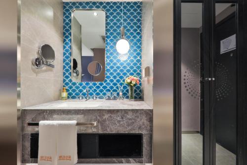 un baño con lavabo y espejo en Crystal Orange Hotel Dahua Hutai Road, en Shanghái