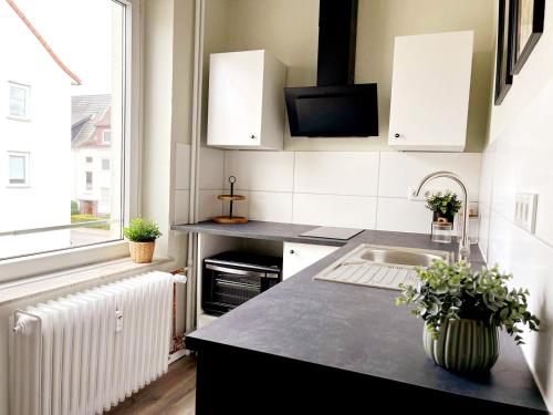 een keuken met een spoelbak en een raam bij Stillvolle Stadtwohnung am Klinikum Bielefeld, zentral und mit Parkplatz! in Bielefeld