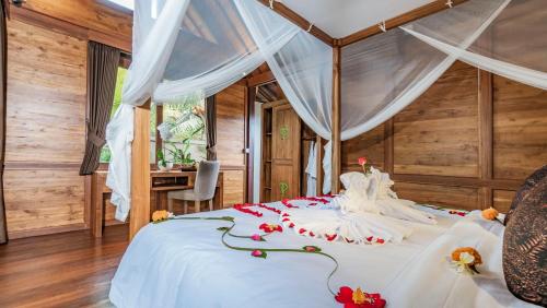 a bedroom with a white bed with flowers on it at The Puspa Villa in Sukawati
