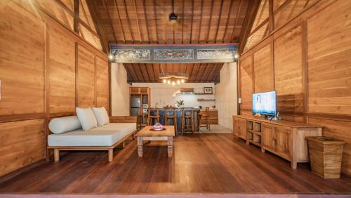 a living room with a couch and a tv at The Puspa Villa in Sukawati
