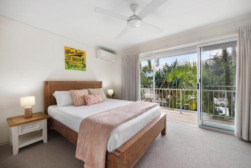a bedroom with a bed and a large window at Moondarah: Pet-Friendly Escape in Noosa Heads