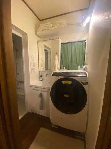 a bathroom with a sink and a mirror at Artful Cats house in Tokyo