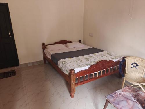 a bedroom with a bed and a chair at Dharinidhama Homestay in SanivÄrsante