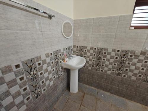 a bathroom with a sink and a mirror at Dharinidhama Homestay in SanivÄrsante