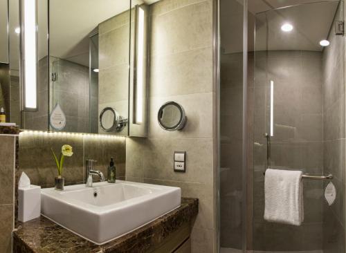 a bathroom with a sink and a shower at Ascott Sentral Kuala Lumpur in Kuala Lumpur