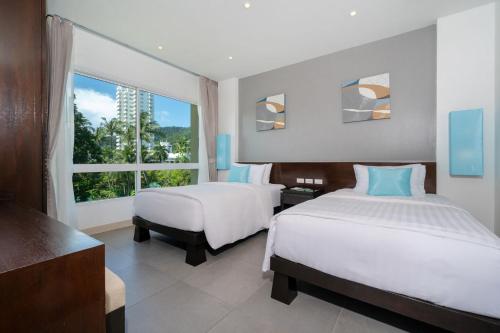 Ένα ή περισσότερα κρεβάτια σε δωμάτιο στο Karon Beachfront Apartment 724