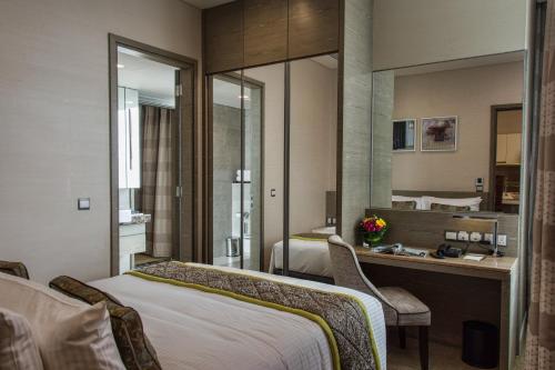 a hotel room with a bed and a desk and mirror at Ascott Sentral Kuala Lumpur in Kuala Lumpur