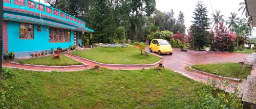 a yellow van parked in front of a blue building at Dharinidhama Homestay in SanivÄrsante
