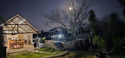 a backyard of a house with a swimming pool at night at Tamboti Farm Self-Catering Accommodation in Tsumeb