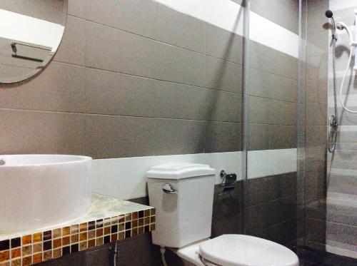 a bathroom with a toilet and a sink and a shower at EZ House in Sukhothai