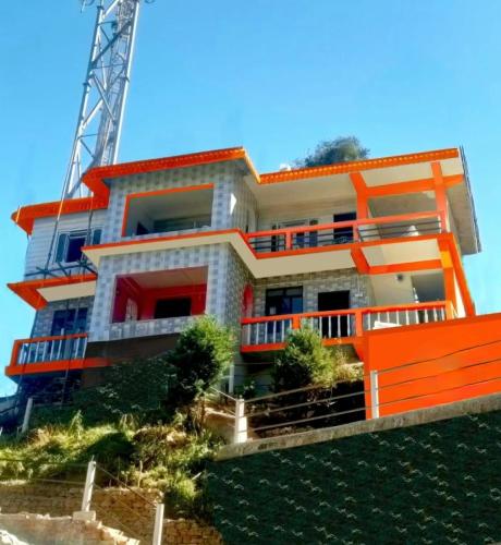 a building on a hill with an orange at The Jungle - RISHOP in Rishop