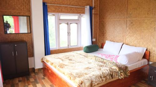 a bed in a room with a window at The Jungle - RISHOP in Rishop