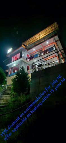 a large building with lights on it at night at The Jungle - RISHOP in Rishop
